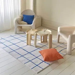 Detailed view of a cozy blue grid faux cashmere rug styled in a modern living room setting.