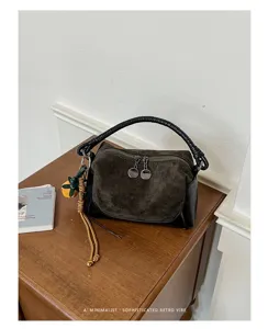 Vista detallada del bolso retro de ante y cuero con elegante asa trenzada para mujeres