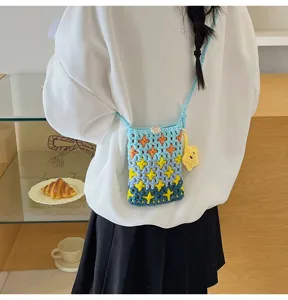 Detailed view of knitted cross-body phone bag with gradient blue star pattern and yellow star pendant.