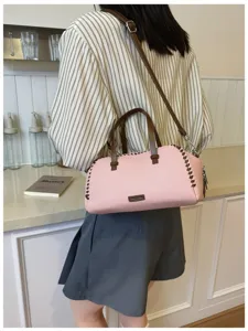 Élégant sac bandoulière rose avec poignées marron et coutures pour femmes au quotidien.