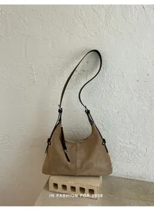 Bruine suède schoudertas detail, vintage hobo stijl riem en ritssluiting close-up aanzicht.