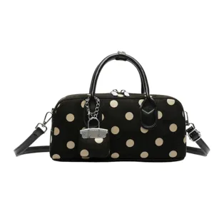 Chic polka dot handbag with black handles, versatile shoulder crossbody bag for daily commute.