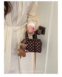 Brown polka dot Boston bag detail with cute teddy bear charm, retro minimalist aesthetic style.