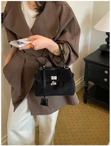 Schicke schwarze Wildleder Handtasche für Damen, elegante Umhängetasche mit Drehverschluss.
