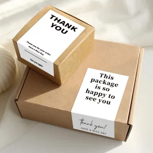 Detail view of kraft paper boxes with minimalist English thank you sealing stickers for packaging.