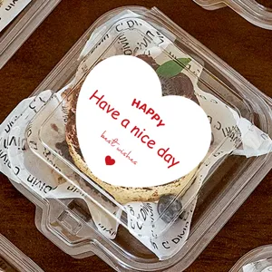 Nahaufnahme eines leckeren Kuchen-Desserts verpackt in einer klaren Plastikbox mit Dekorationspapier.