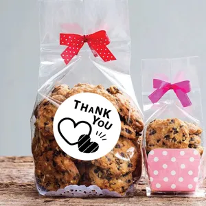 Clear cellophane cookie packaging bags with red bow and thank you sealing stickers for baking.