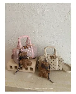 Chic polka dot Boston bag with cute teddy bear charm, stylish retro shoulder handbag for women.