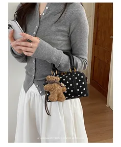 Chic polka dot Boston handbag featuring a plush bear pendant, stylish retro commuter bag.
