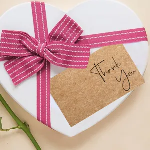 Kraft paper thank you card close up detail featuring gift tag inside white heart box.