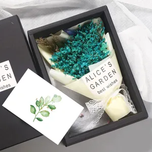 Detailansicht der edlen Geschenkbox mit blauem Trockenblumenstrauß und Blumenkarte.