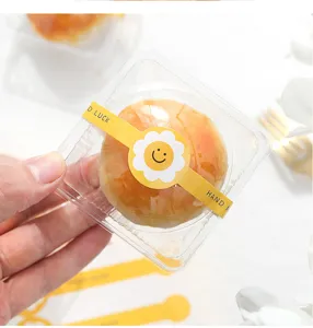 Backverpackung Aufkleber Detailaufnahme, gelbes niedliches Smiley-Design, transparente Box.