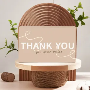 Minimalist thank you card detail view with elegant wooden stand and fresh plant props