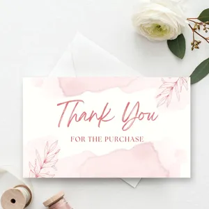 Close-up detail shot of a pink watercolor thank you card with delicate floral line art.