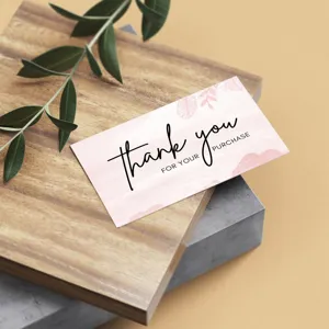 Close-up detail of a minimalist pink floral thank you card displayed on wooden background.