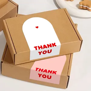 Detail view of minimalist pink and white thank you arch sealing stickers for gift packaging boxes.