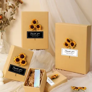 Detailed view of kraft paper gift boxes decorated with sunflowers and thank you labels.