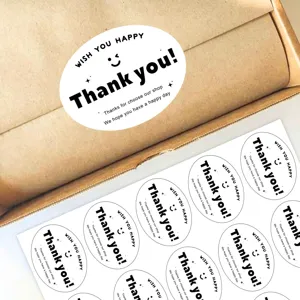 Close-up detail of black oval thank you stickers, perfect for gift wrapping and bakery sealing.