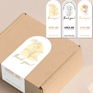 Detail of minimalist floral arch sealing stickers on gift box, decorative adhesive labels.