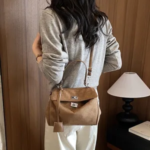 Braune Wildleder Handtasche für Damen, elegante Henkeltasche mit Drehverschluss.