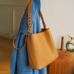 Leather shoulder bag detail, stylish dumpling handbag closeup, casual large capacity commuter bag.