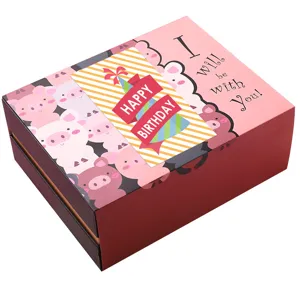 Gros plan de la boîte cadeau rose rectangulaire avec des cochons de dessin animé et carte.