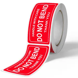 Roll of red warning self-adhesive stickers with clear text for parcel shipping and logistics.