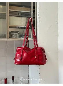 Détail de sac à bandoulière en cuir verni rouge, élégant sac Boston grand format chic.