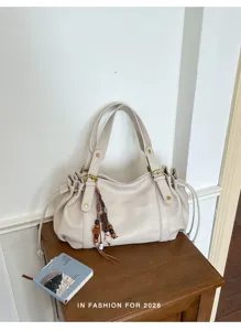 Detailansicht der vintage beige Schultertasche mit Schnallen und Tunnelzug Elementen.