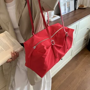 Nahaufnahme der roten Nylon-Schultertasche mit Doppelriemen und sicherem Reißverschluss.