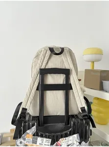 Detailansicht des leichten beige Stoffrucksacks auf Koffergriff mit Wohnaccessoires im Setup.