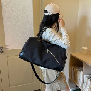 Gros plan détaillé du sac de voyage en toile noire avec fermeture éclair et bandoulière.