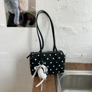 Detalle de bolso de boliche de lona de lunares, elegante bolso de hombro con lazo chic.