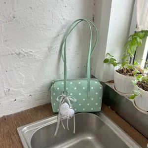 Elegante bolso de bolos verde con lunares y un bonito colgante para su uso diario.