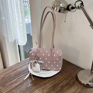 Primer plano detallado del elegante bolso de mano tipo boliche rosa con dije de perla.