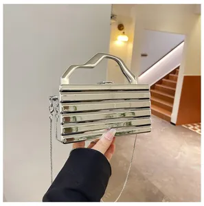 Vista dettagliata della borsa clutch metallica con manico scultoreo e catena.