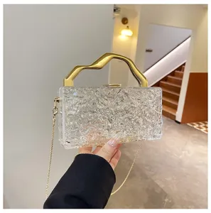 Borsa pochena da sera in acrilico trasparente con manico dorato irregolare e catena.
