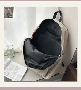 Detaillierte Innenansicht des beigen Canvas-Rucksacks mit geräumigem Fach und Innentasche.