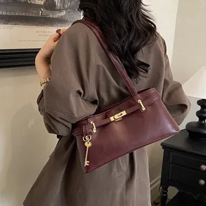 Retro Pendler Schulter Unterarm Damentasche, weinrotes Leder mit Metallschloss und Schlüsseln.