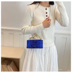 Primo piano dettagliato della borsa da sera in acrilico blu con manico dorato unico.