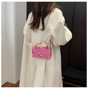 Elegante borsa da sera rosa con texture metallica, manico rigido e pratica tracolla.