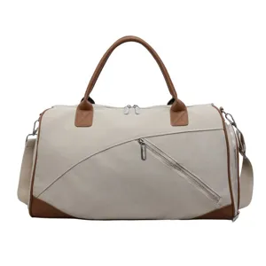 Grand sac de voyage de grande capacité en toile avec des accents en cuir et bandoulière.