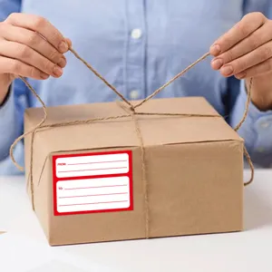 Vista detallada de una pegatina de dirección postal manuscrita autoadhesiva en caja.