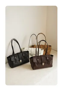 Detailed view of multiple color soft leather shoulder tote bags with metal lock closure.