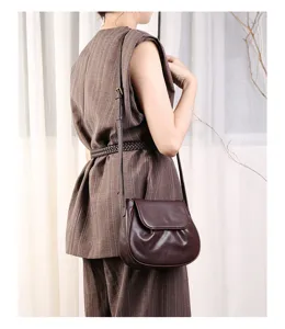 Brown leather shoulder saddle bag detail shot showing crossbody wearing style and fine strap.