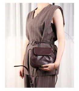 Brown leather saddle bag detail, vintage crossbody shell purse for women daily use.