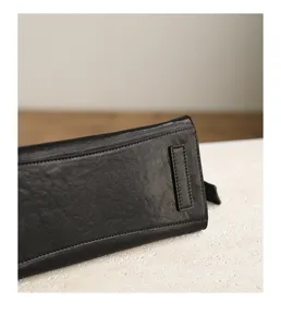 Black genuine leather handbag detail view, retro wrinkled design, large capacity casual tote bag.