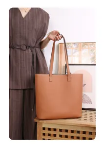 Classic brown genuine leather tote bag featuring double handles and spacious design.
