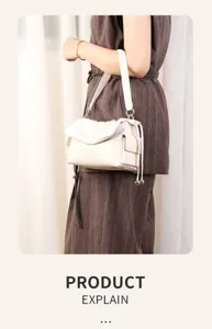Detailed view of white pleated shoulder bag with side pocket and drawstring decor.