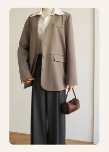 Minimalist cylindrical shoulder bag detail, soft leather texture, versatile casual daily wear.